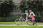 Boy in street learning to ride bicycle