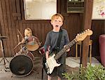 Children playing guitar and drums in band