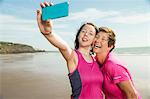 Mother and daughter taking selfie on beach, Folkestone, UK