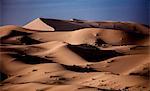 Sand dunes in wave shapes, formed by the action of wind and weather, in the desert.