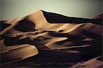 Sand dunes in wave shapes, formed by the action of wind and weather, in the desert.
