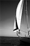 Two people jumping from a yacht into the ocean.