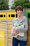 Woman taking recyclables to recycling bin