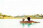 Couple relaxing together in lake, rear view