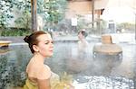 Caucasian woman with Japanese friend bathing at traditional hot spring, Tokyo, Japan