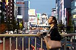 Caucasian woman downtown Tokyo at night, Tokyo, Japan