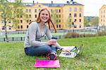 Teenage girl on lawn using laptop