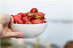 Hand with bowl of strawberries