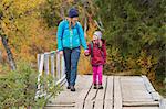 Mother with daughter walking through bridge