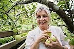 Smiling woman picking apples