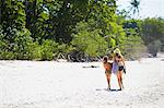 Mother with daughter walking on beach