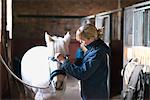 Woman with horse in stable