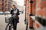 Young woman with bicycle on the phone