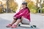 Woman sitting on longboard