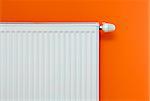 Heating Radiator Attached on the Orange Wall