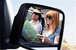 Couple with map in car mirror