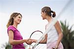 Girls shaking hands on tennis court