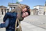 Man carrying girlfriend in town square