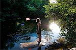 Woman catching fish with net in river