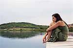 Woman crouched on pier