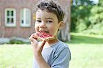 Boy eating bread with jam outdoors