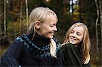 Mother and daughter smiling in forest