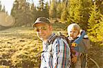 Man carrying son on back outdoors