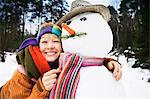 Smiling woman hugging snowman