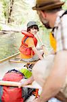 Father and son packing canoe on river