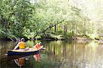 Father and son paddling canoe on river