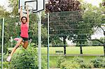 Woman hanging from basketball net