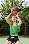 Woman shooting basketball on court