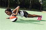 Woman doing push ups on basketball court