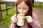Girl drinking cocoa outdoors