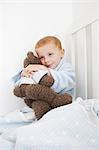 Boy hugging teddy bear in bed