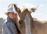 Boy petting horse outdoors