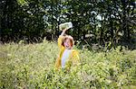 Girl with jar in field of tall grass