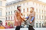 Couple holding hands on city street