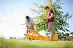 Men playing with toy airplane in park