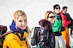 Young woman wearing ski clothes with friends in background