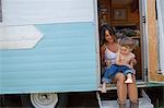 Mother and son sitting in doorway of motor home