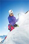 Female mountain climber using ice pick