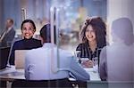 Businesswomen smiling in conference room meeting