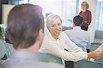 Smiling businesswoman talking to businessman in conference audience