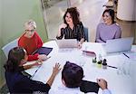 Business people talking, working at laptops in conference room meeting