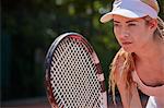 Focused young female tennis player holding tennis racket