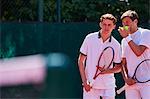 Young male tennis doubles players talking, strategizing