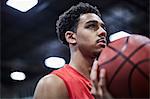 Portrait serious, focused young male basketball player holding basketball