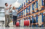 Male and female supervisors checking inventory in fiber optics factory