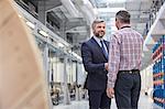 Business owner and supervisor handshaking in fiber optics factory